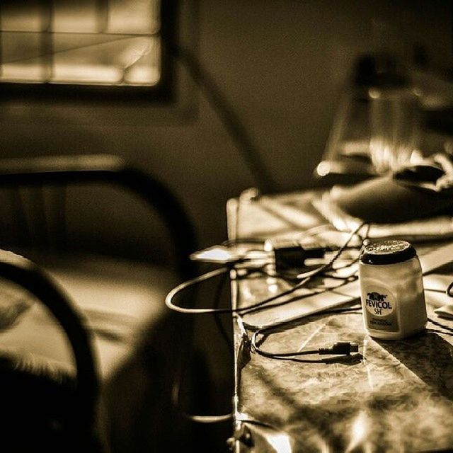 indoors, home interior, close-up, selective focus, table, reflection, focus on foreground, technology, land vehicle, window, still life, vehicle seat, glass - material, chair, domestic room, eyeglasses, mode of transport, domestic kitchen