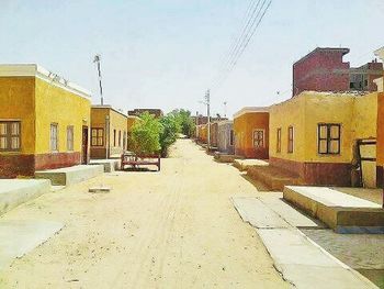 Empty road with buildings in background