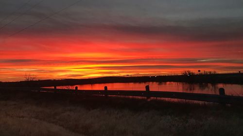 Scenic view of silhouette field against sky during sunset