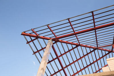 Low angle view of crane against clear blue sky