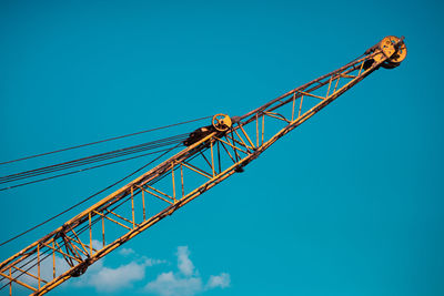 Low angle view of crane against blue sky