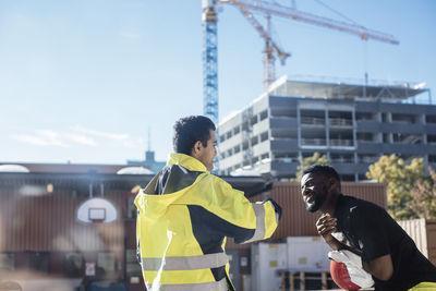 Multi-ethnic students standing outside auto mechanic school