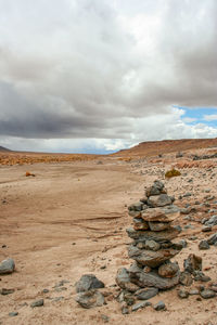 View of sandy beach against cloudy sky