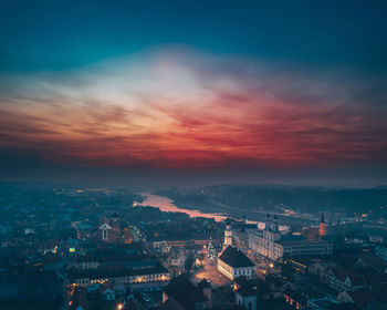 High angle view of illuminated city against sky at sunset