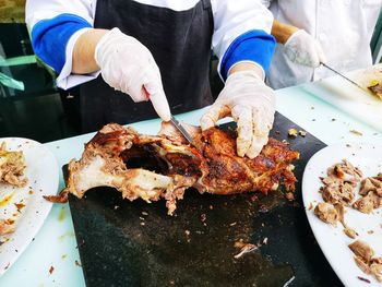 Midsection of person preparing food on barbecue grill