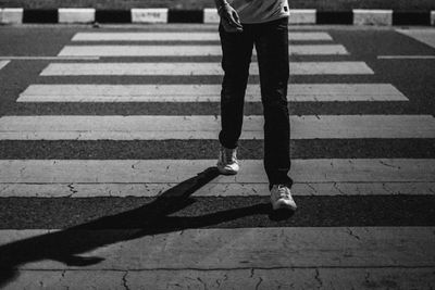 Low section of man walking on road