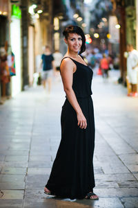 Portrait of woman standing on footpath