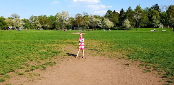 Rear view of woman on grassy field against sky