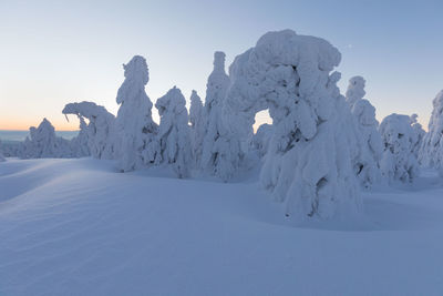 Snow covered landscape against clear sky