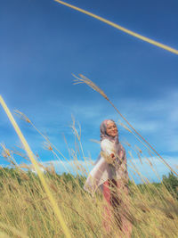 Woman on field against sky