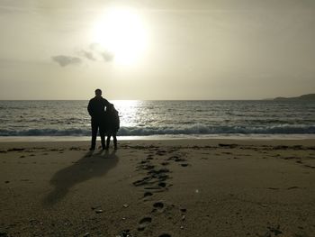 Rear view of man on beach against sky