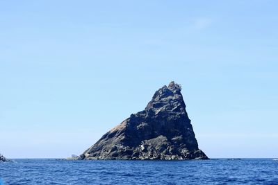 Scenic view of rock formation in sea against sky