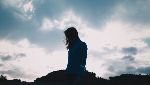 Low angle view of silhouette woman standing against sky