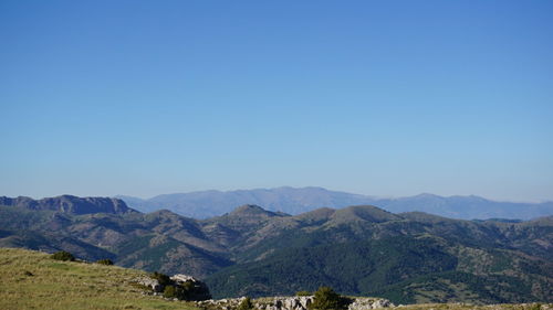 Scenic view of mountains against clear blue sky