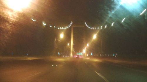 Cars on road against sky at night