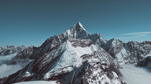 Scenic view of snowcapped mountains against clear sky