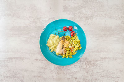 High angle view of pasta with seafood and vegetables in plate on wooden table