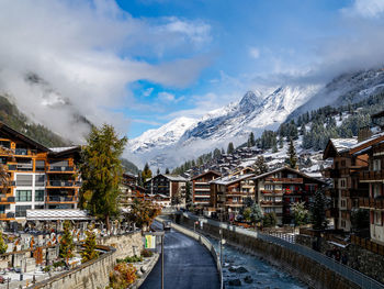 Road amidst buildings against sky during winter