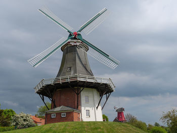 Traditional windmill on field against sky