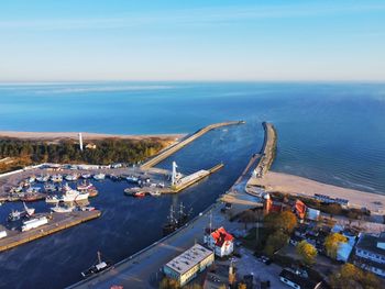 High angle view of city by sea against sky