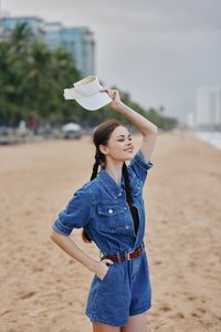 Young woman standing at sandy beach