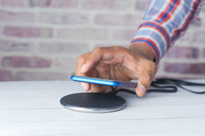 Midsection of man using mobile phone on table