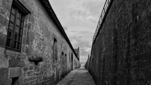 Narrow alley amidst buildings against sky