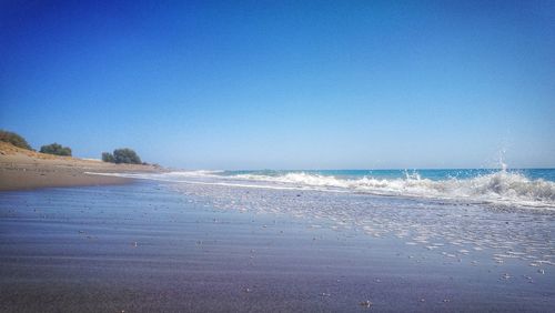 Scenic view of beach against clear blue sky