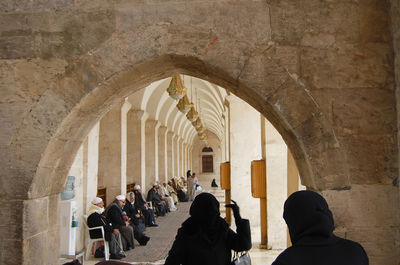 Rear view of people in corridor of historic building