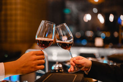 Cropped hands of man and woman toasting wine