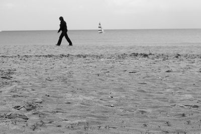 Silhouette of people walking on beach