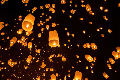 Low angle view of illuminated lanterns hanging against sky