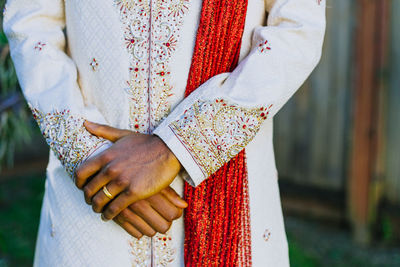 Midsection of woman standing by cross