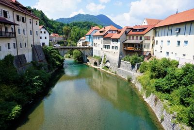 River amidst buildings in town against sky