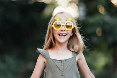 Portrait of young woman wearing sunglasses standing outdoors