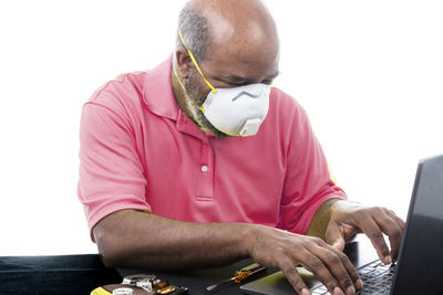Midsection of man using mobile phone while sitting on table