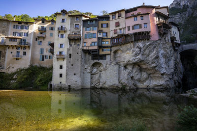 Buildings by lake against sky in city