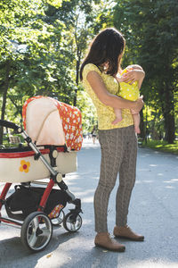 Woman carrying baby on road