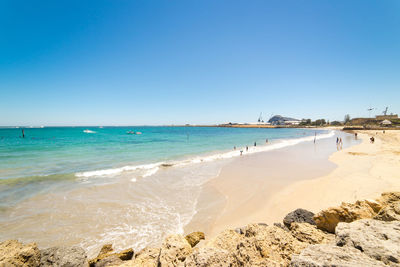 Scenic view of beach against clear blue sky