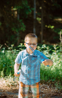 Portrait of boy standing in forest