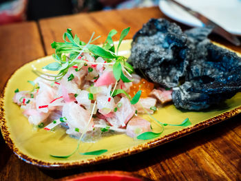 High angle view of ceviche served on wooden table