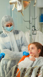 Side view of female doctor examining patient at clinic