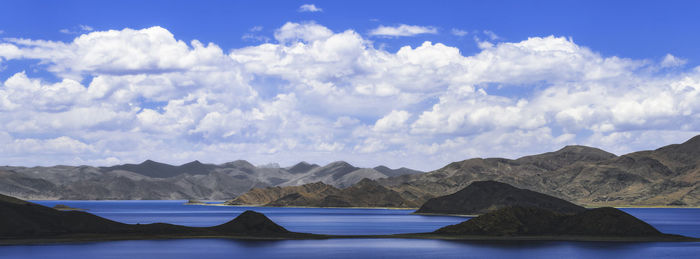 Scenic view of sea and mountains against sky