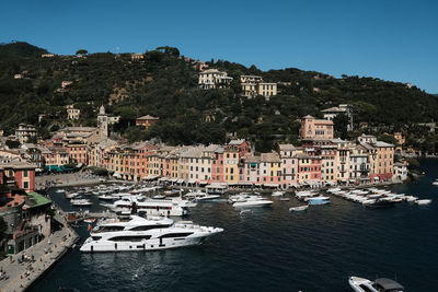 Aerial view of townscape by sea against clear sky