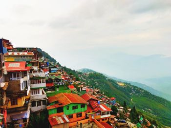 High angle view of houses on mountain against cloudy sky