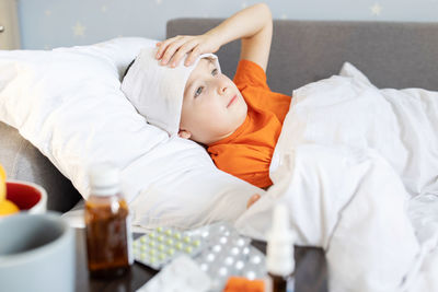 Portrait of woman lying on bed at clinic