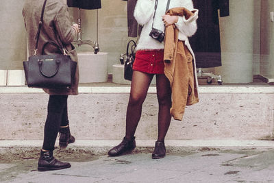 Low section of people standing on sidewalk