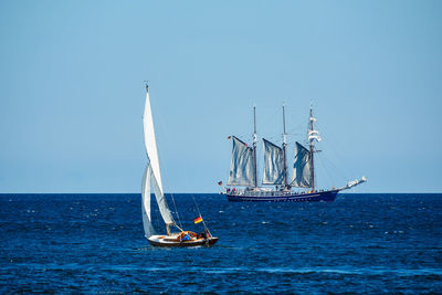 Ship sailing in sea against clear sky