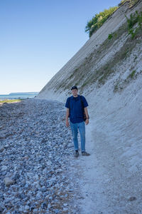 Full length of man standing on street against sky