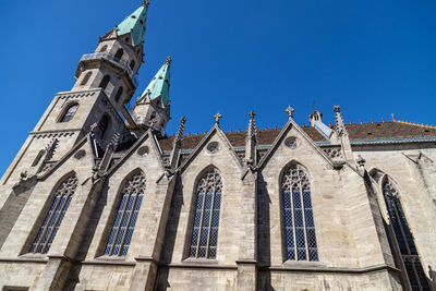 Low angle view of ornate building against clear blue sky